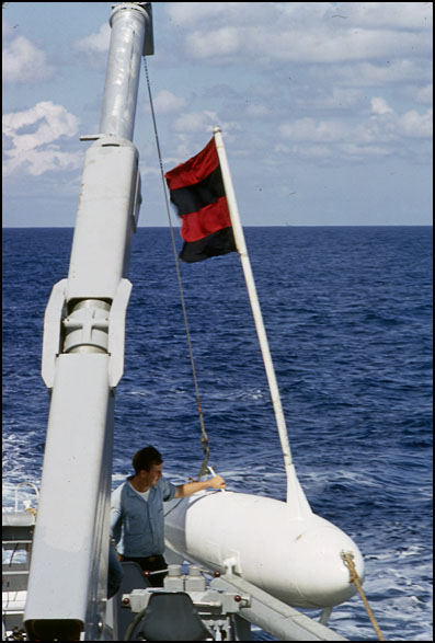 Here is another unique installation.  Venture was the only MSO to have two one ton hydraulic cranes installed (in June, 1960) on the fantail for the streaming of minesweep gear.<br>BMC Smith at the controls. 