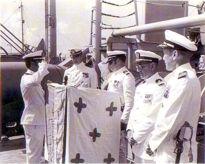 ENS Ernie Perez handing the OOD spyglass to secure the quarterdeck watch to LTCDR Douglas Conwell. Courtesy of CDR Douglas Conwell USN (Ret)